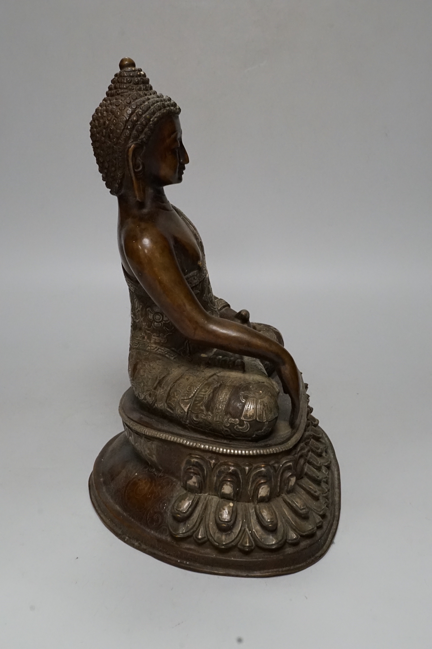 A silver overlaid bronze figure of Buddha Shakyamuni, 26cm